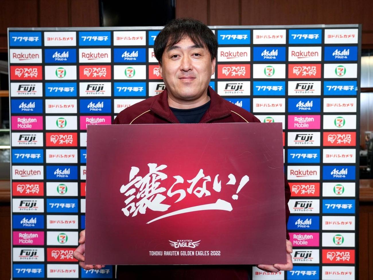 今季のチームスローガン「譲らない！」のボードを手にする楽天石井GM兼任監督（提供楽天野球団）