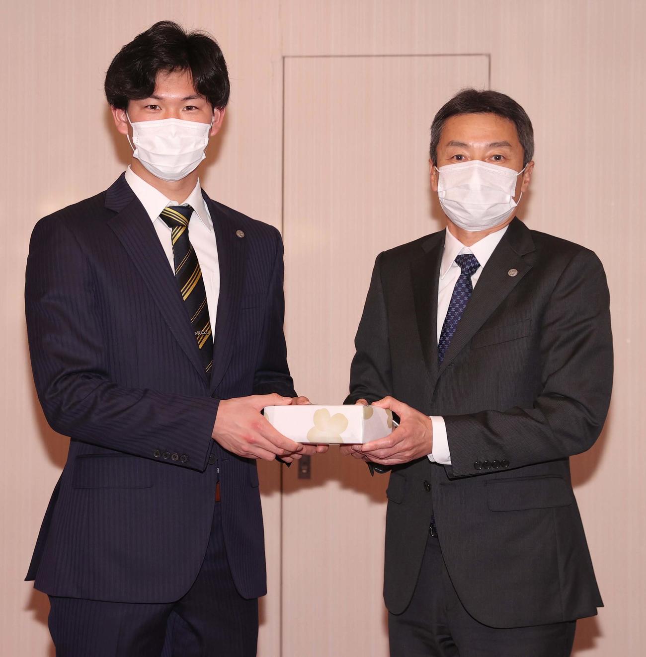 阪神タイガース百北球団社長から新成人の記念品を受け取る及川（代表取材）