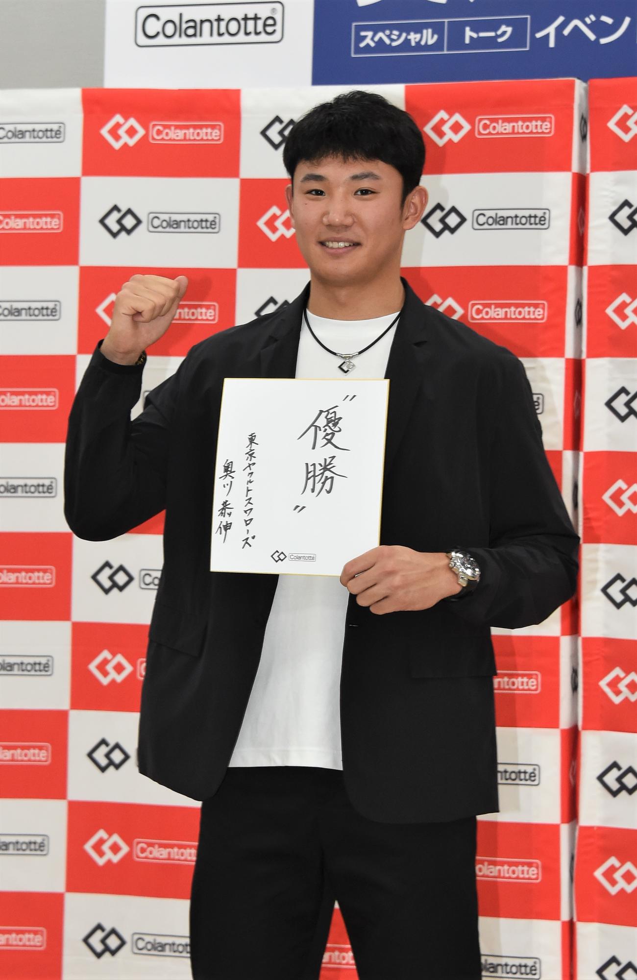 トークイベントに出演したヤクルト奥川は「優勝」と記した色紙を手にガッツポーズ（撮影・鈴木正章）