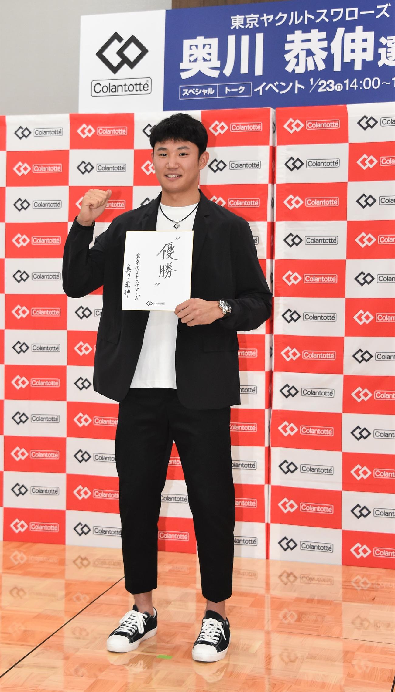 トークイベントに出演したヤクルト奥川は「優勝」と記した色紙を手にガッツポーズ（撮影・鈴木正章）