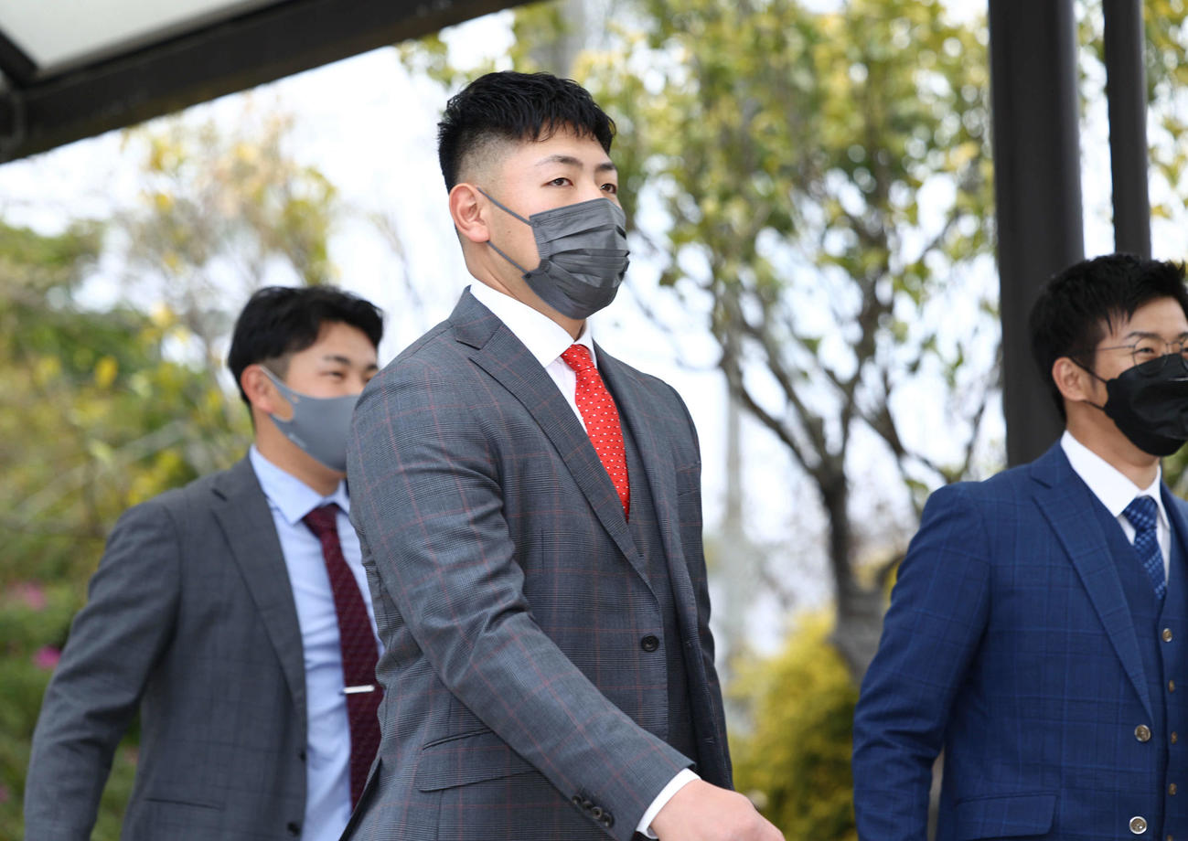 宮崎空港に到着し、移動バスに向かう巨人岡本和。後方左から堀岡、松原（撮影・河田真司）