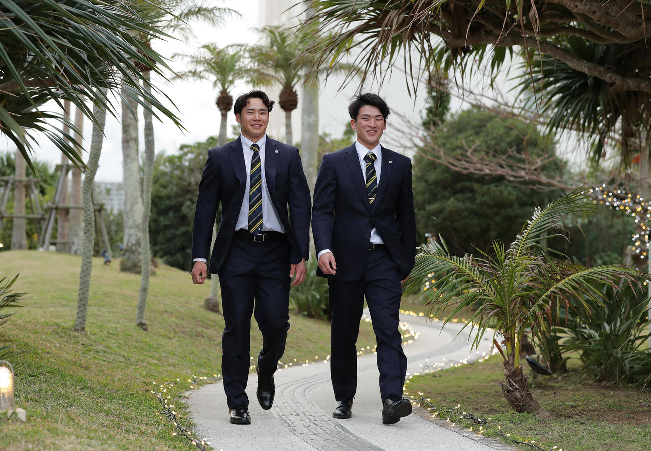 沖縄入りしてチーム宿舎に到着し、ホテルの敷地内を歩く阪神遠藤（左）と高寺（撮影・前田充）