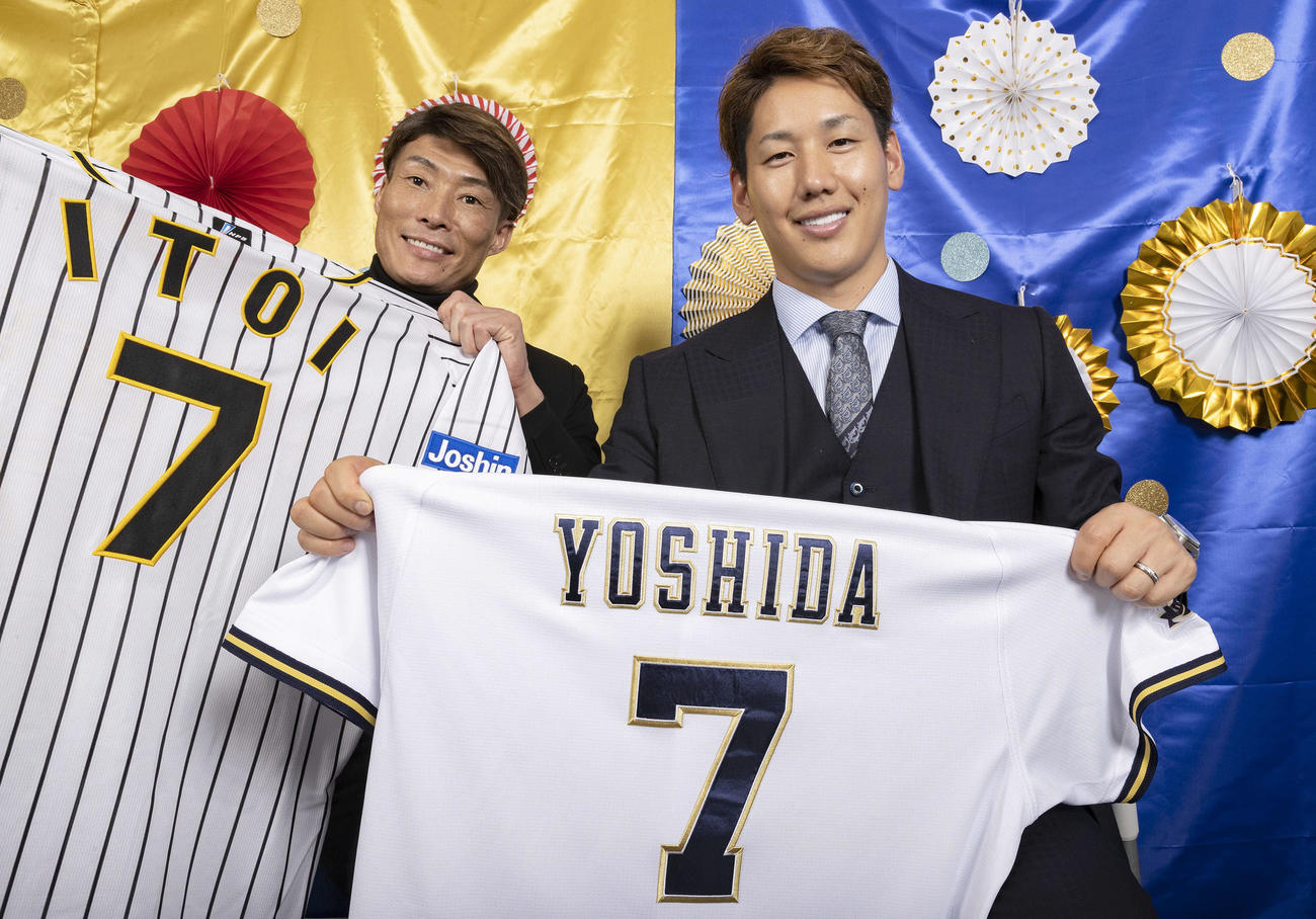 互いに背番号「7」のユニホームを手に笑顔で日本一を誓う阪神糸井（左）とオリックス吉田正