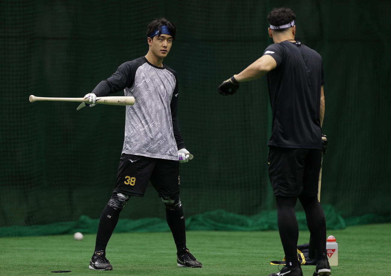 バットを手に阪神佐藤輝（右）と言葉を交わす小幡（撮影・前田充）