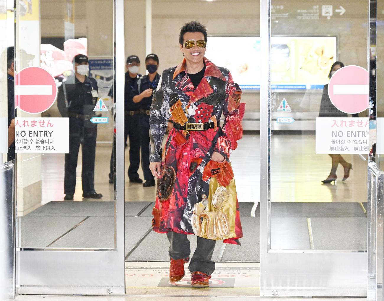 グローブ柄のコート姿で那覇空港に到着した日本ハム新庄監督（撮影・滝沢徹郎）