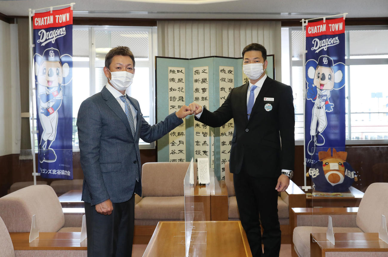 キャンプ地となる北谷町役場を訪れ渡久地町長（右）とグータッチを交わす立浪監督（左）（代表撮影）