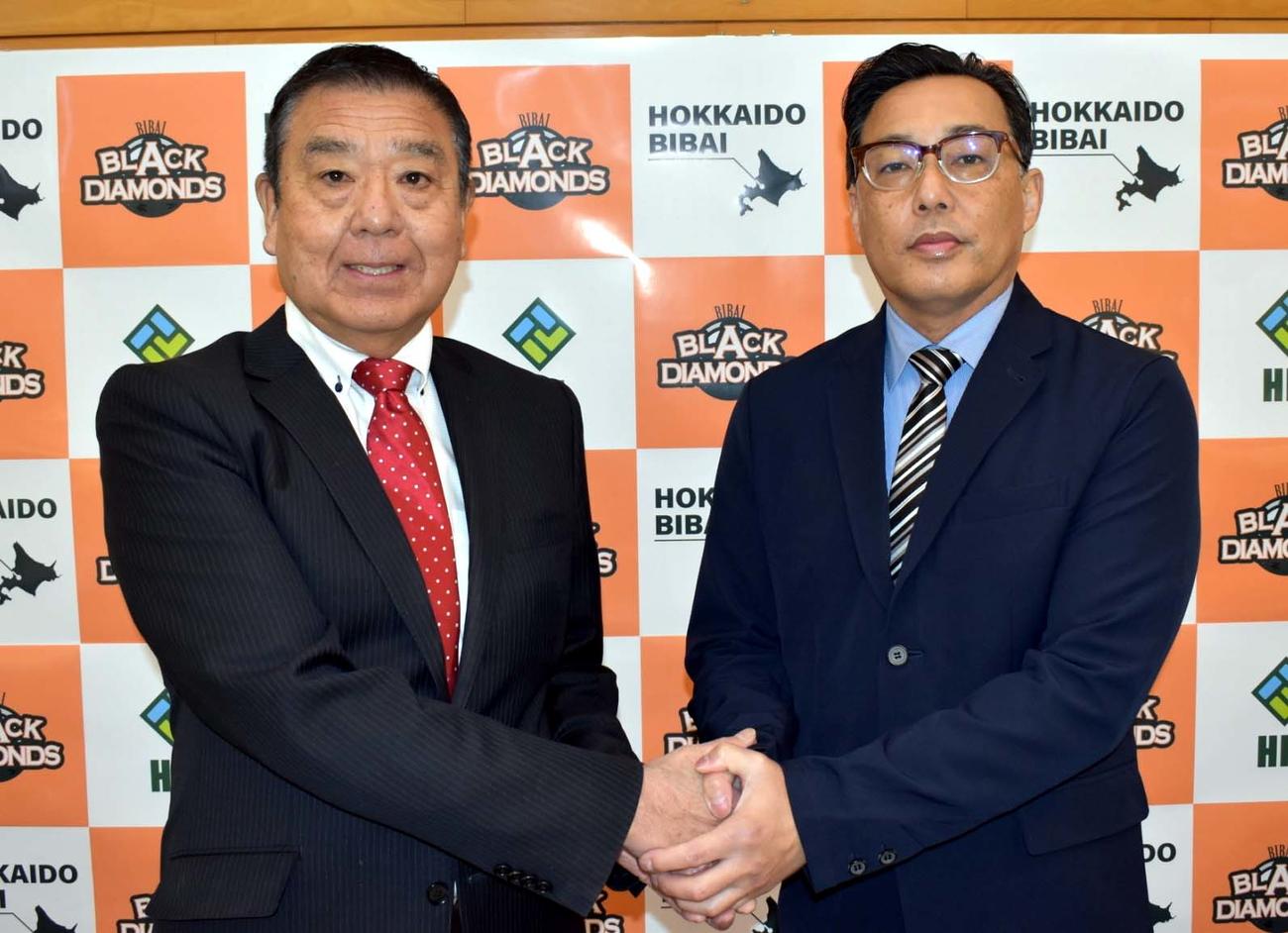 荘司代表と握手する河上新監督（左）（球団提供）