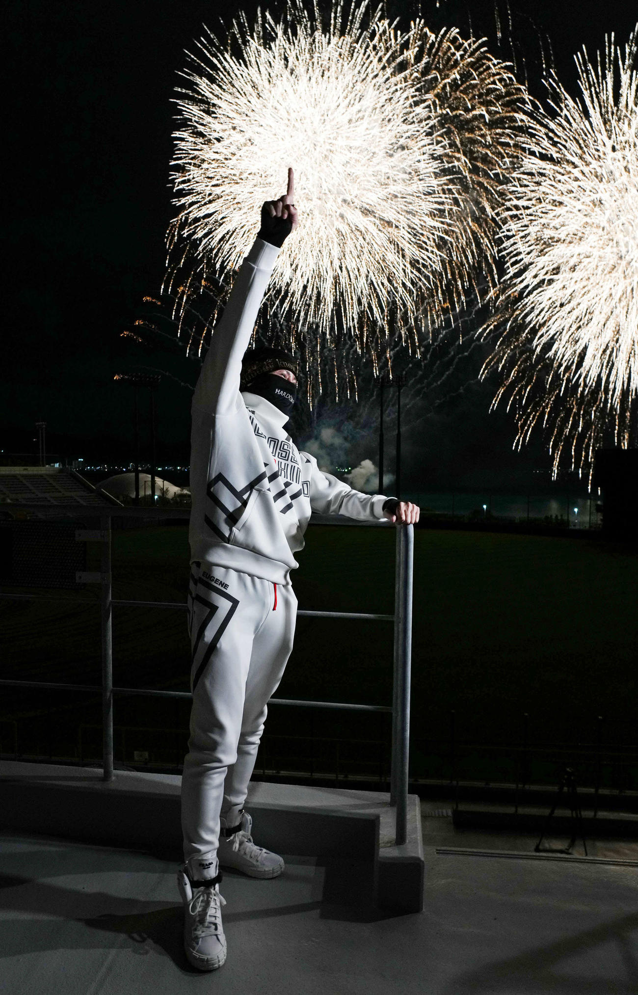 自身が主催した花火ショーで打ち上げられた花火を背に指を突き上げる日本ハム新庄監督