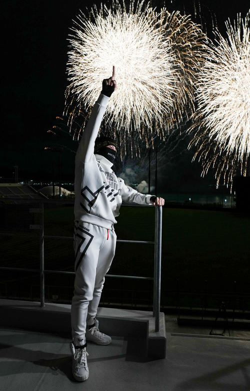 自身が主催した花火ショーで打ち上げられた花火を背に指を突き上げる日本ハム新庄監督
