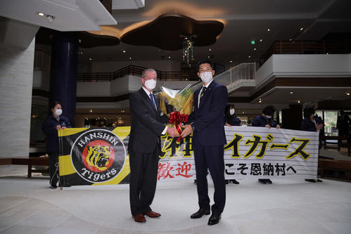 チーム宿舎に到着した阪神矢野監督（右）はホテルの総支配人ラファエルさんから歓迎の花束を受け取る（球団提供）