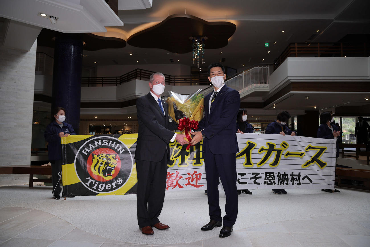 チーム宿舎に到着した阪神矢野監督（右）はホテルの総支配人ラファエルさんから歓迎の花束を受け取る（球団提供）