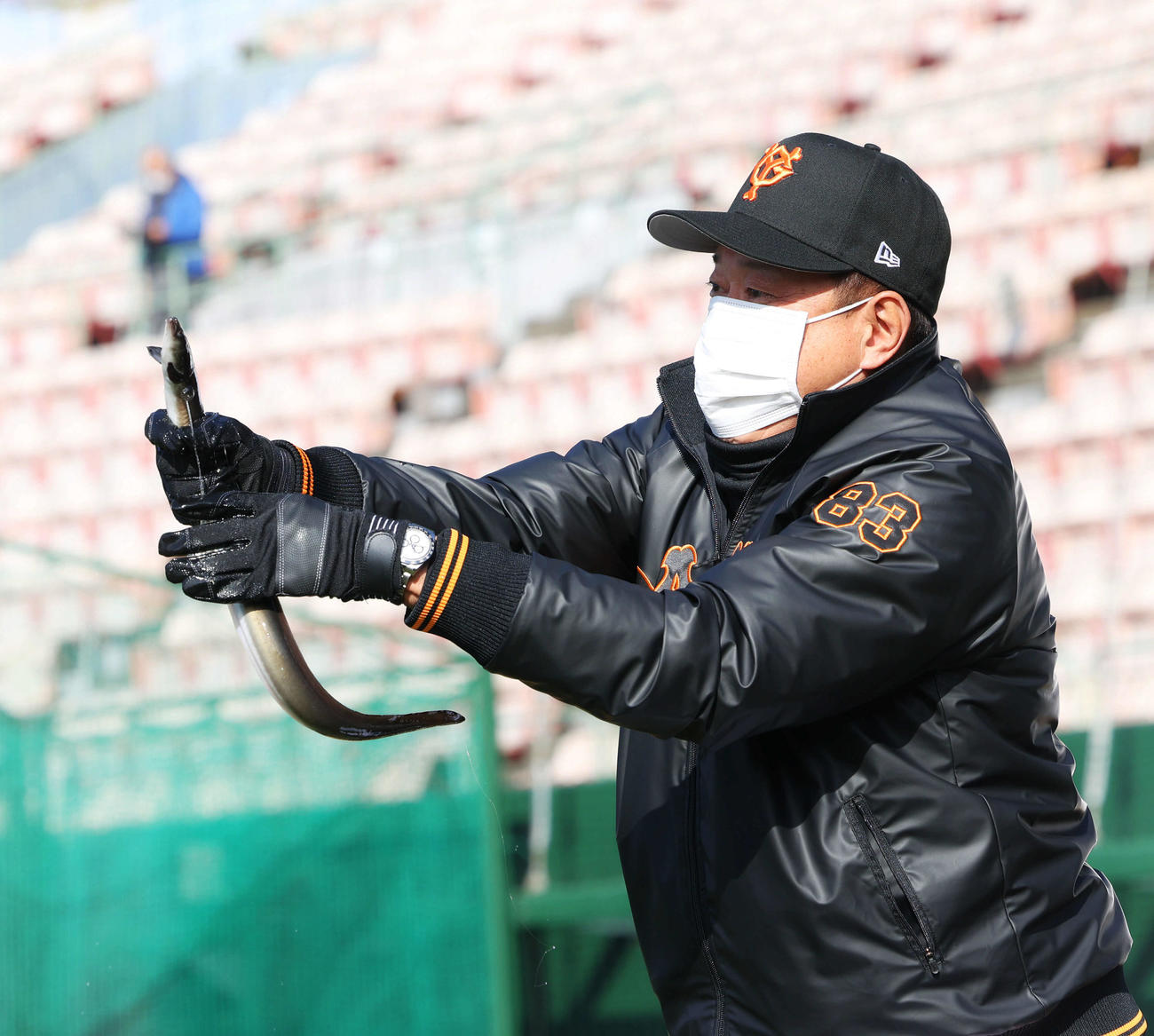 特産品の贈呈式でウナギを必死につかむ原監督（撮影・河田真司）