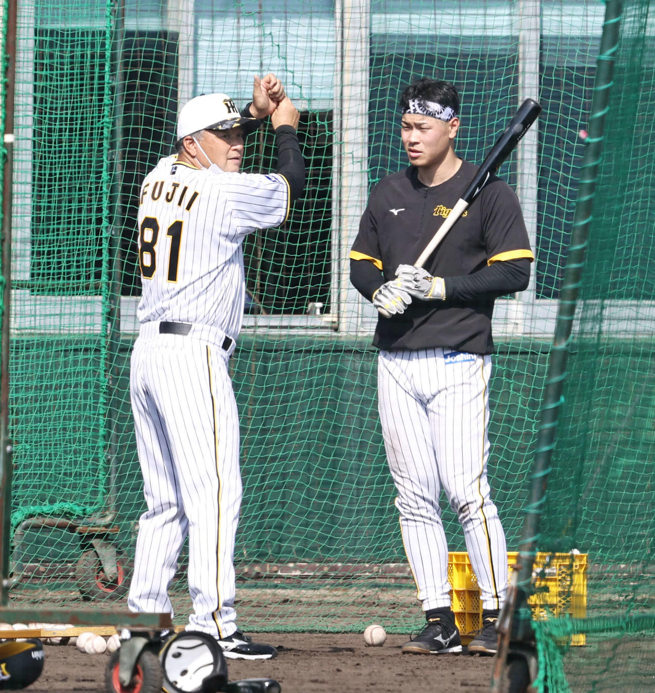 藤井康コーチ(左）からアドバイスを受ける佐藤輝（撮影・加藤哉）