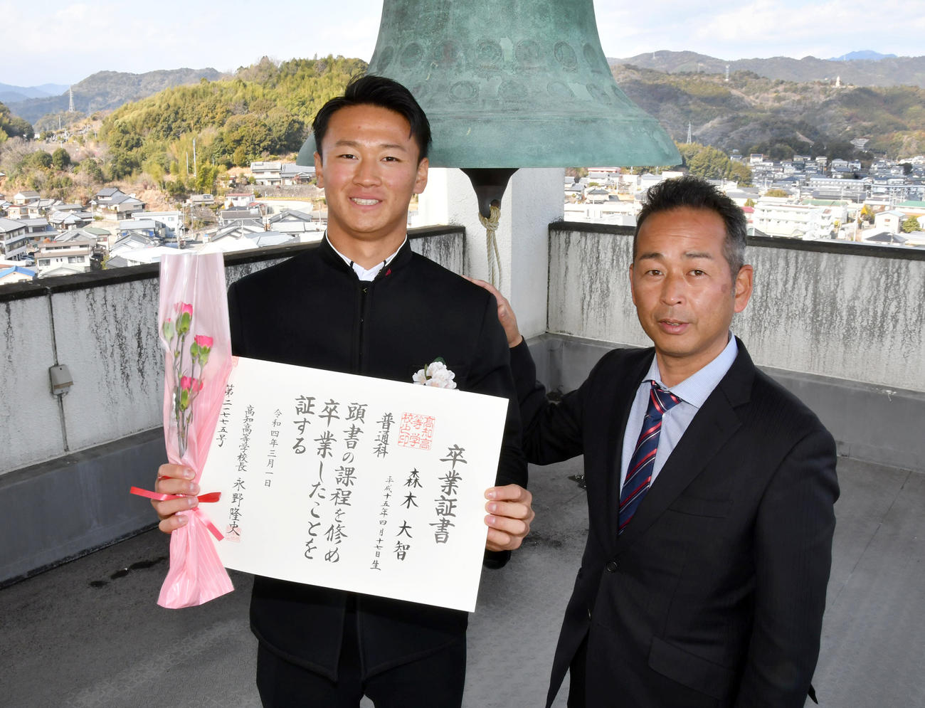 高知高校のシンボル「世界の鐘」の前で卒業証書を手にする森木。右は浜口監督（代表撮影）