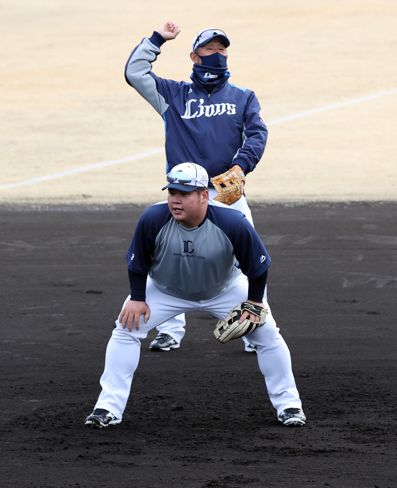 西武の春季キャンプ2日目、辻監督（奥）が見つめる中、早出の渡部はノックを受ける（撮影・浅見桂子）