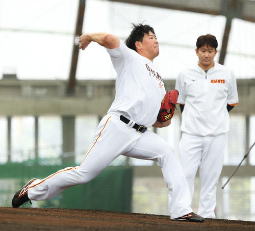 ブルペン投球する巨人山口（左）を見る菅野（撮影・河田真司）