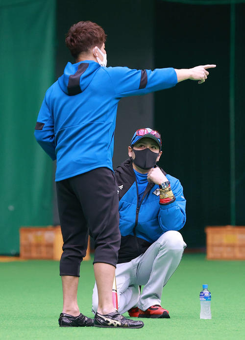 臨時コーチとして日本ハムキャンプを訪れた武井壮（手前）の話を聞く新庄監督（球団提供）