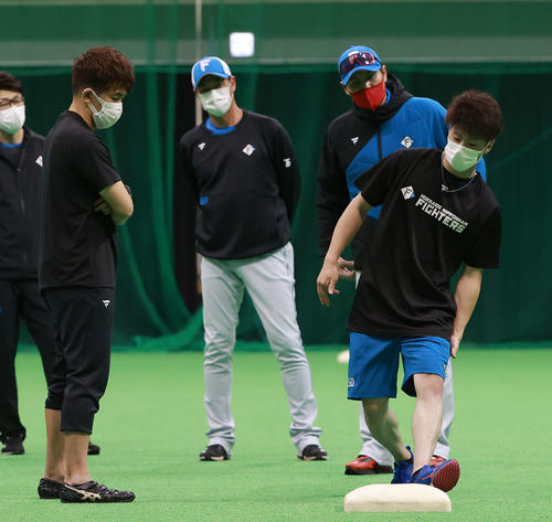 武井臨時コーチ（左）の指導を受ける日本ハム五十幡（右手前）。右後方は新庄監督（球団提供）