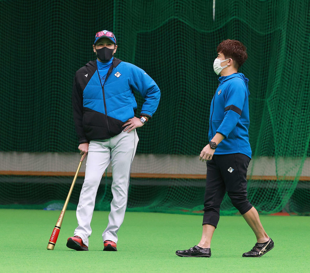 臨時コーチとして日本ハムキャンプを訪れた武井壮（右）と談笑する新庄監督（球団提供）