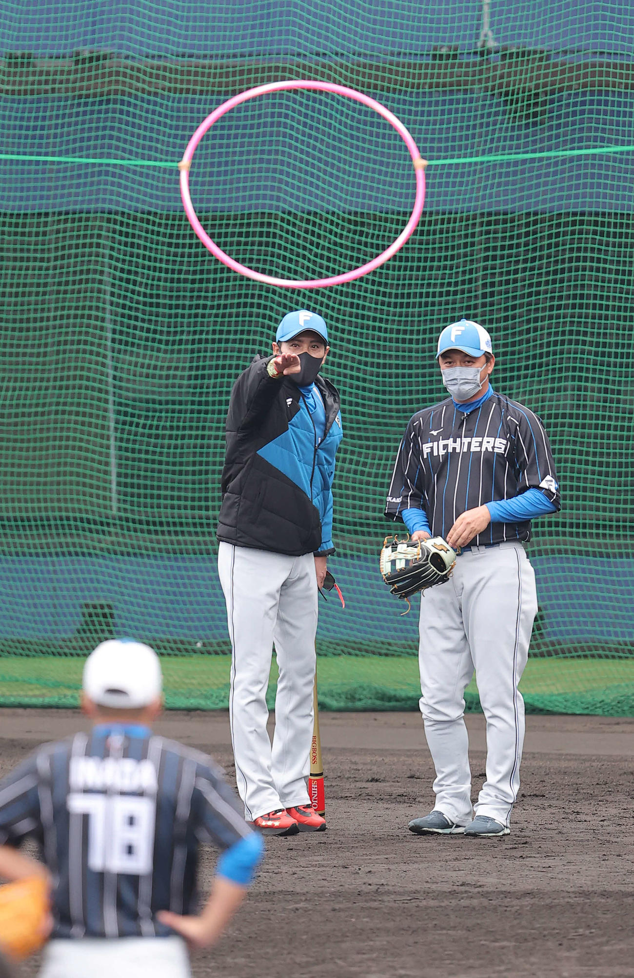 日本ハム金子コーチ（右）にフラフープの間に送球する練習について説明する新庄監督（撮影・河野匠）