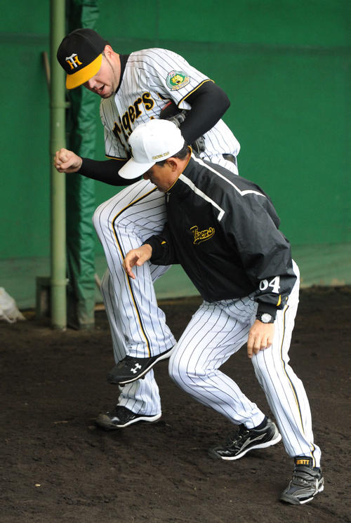 2010年阪神春季キャンプでメッセンジャーに軸足でしっかり立つ練習を行う久保康生コーチ