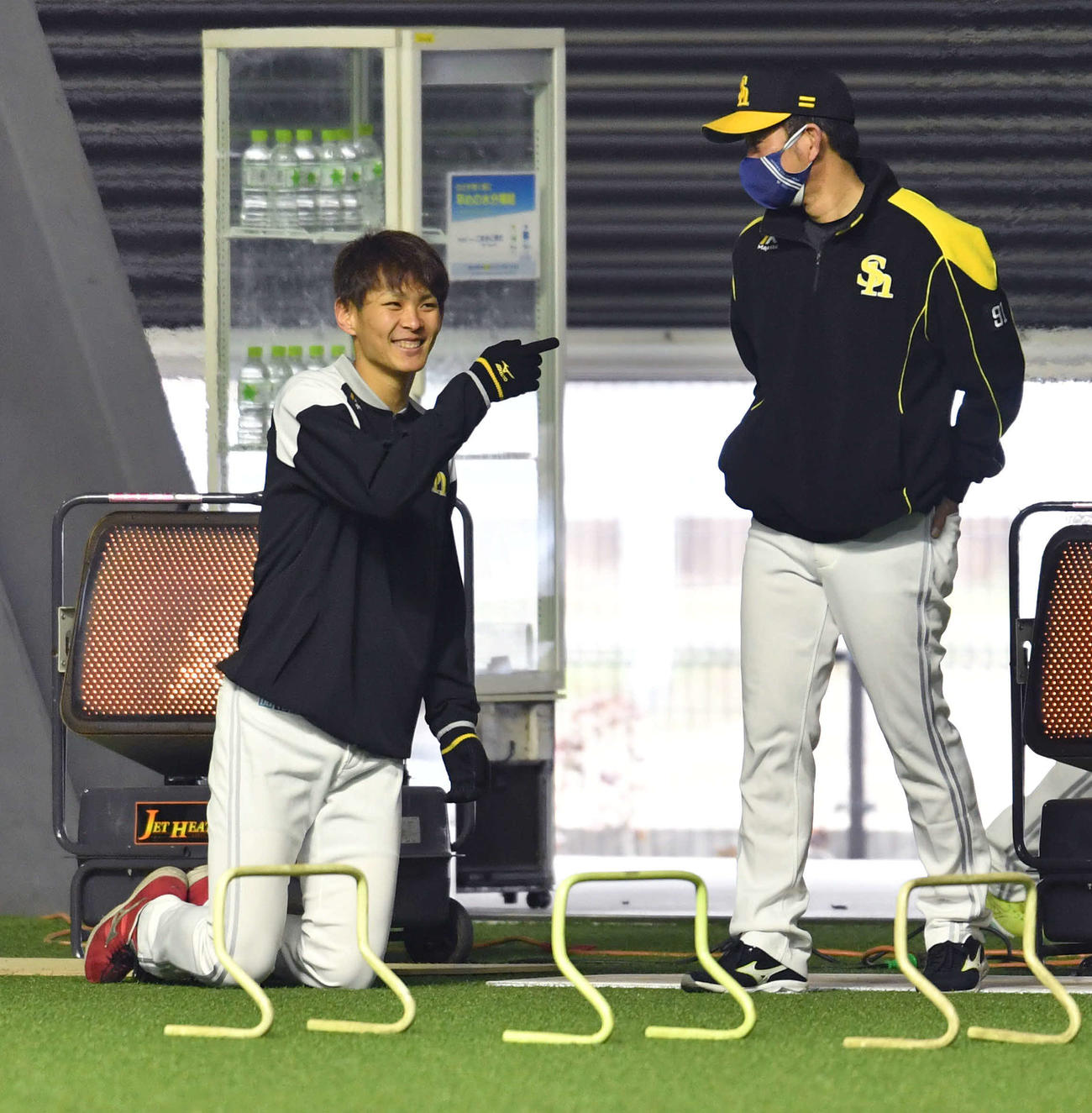 佐久本コーチ（右）と談笑する泉（撮影・岩下翔太）