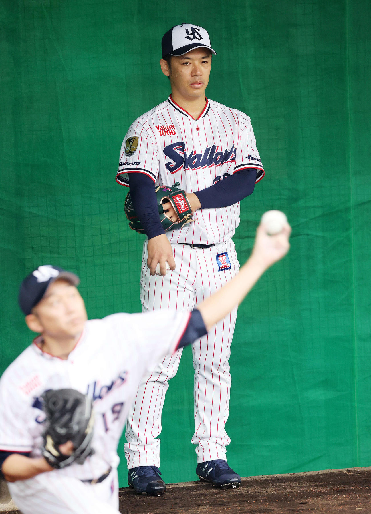 投球練習を終え、石川雅規（手前左）の投球を見つめるヤクルト小川（撮影・鈴木正人）
