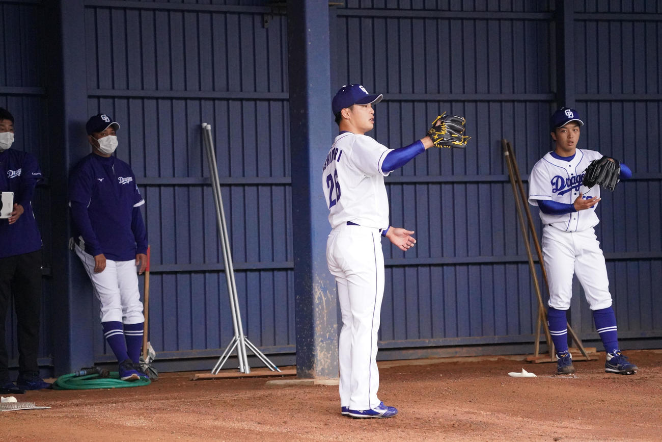 ブルペンで投球練習をする（右から）山本、石森らを見つめる落合ヘッド兼投手コーチ（撮影・森本幸一）