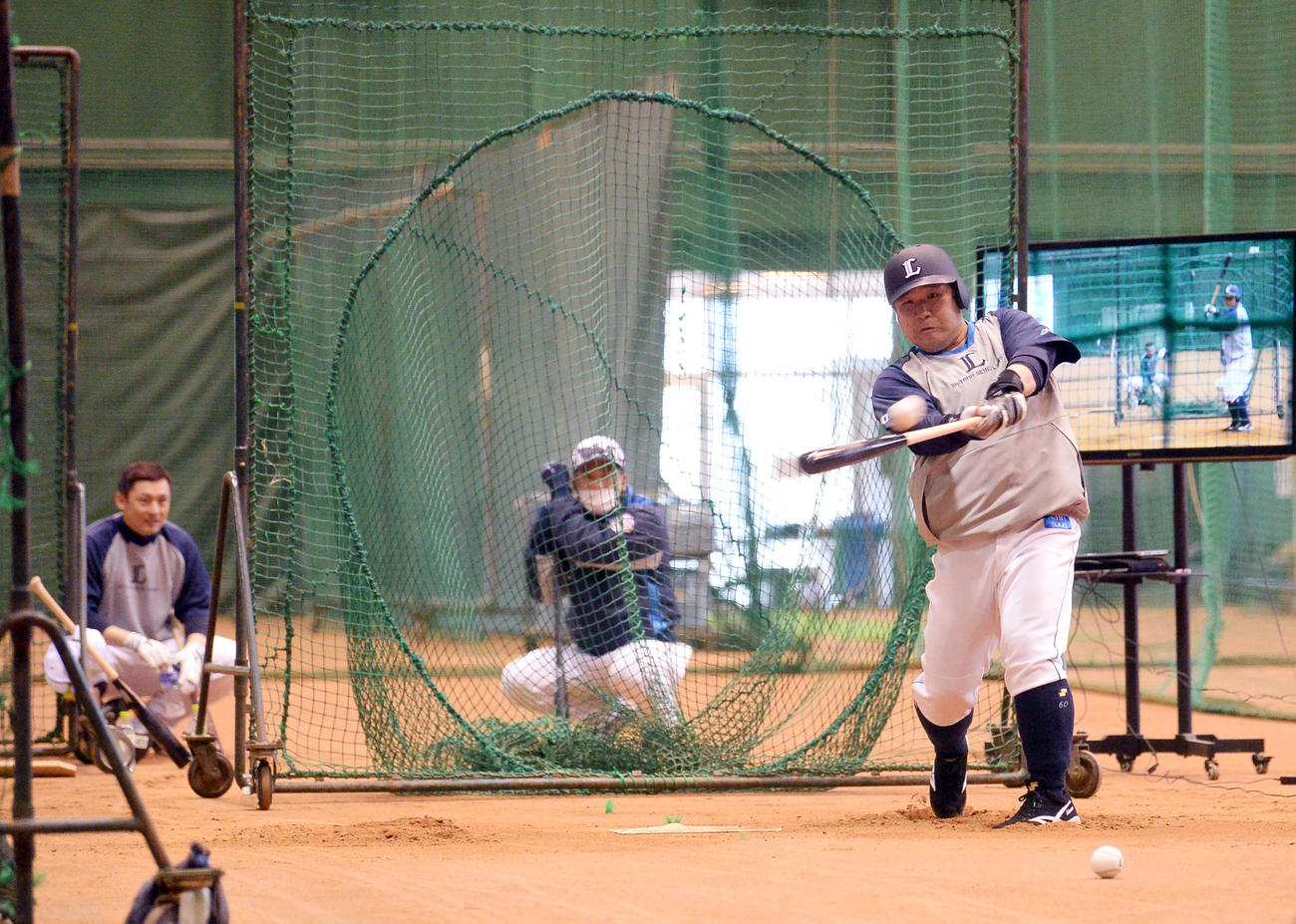 室内練習場で栗山（左）松井ヘッドコーチ（中央）が見守る中で打撃練習する西武中村