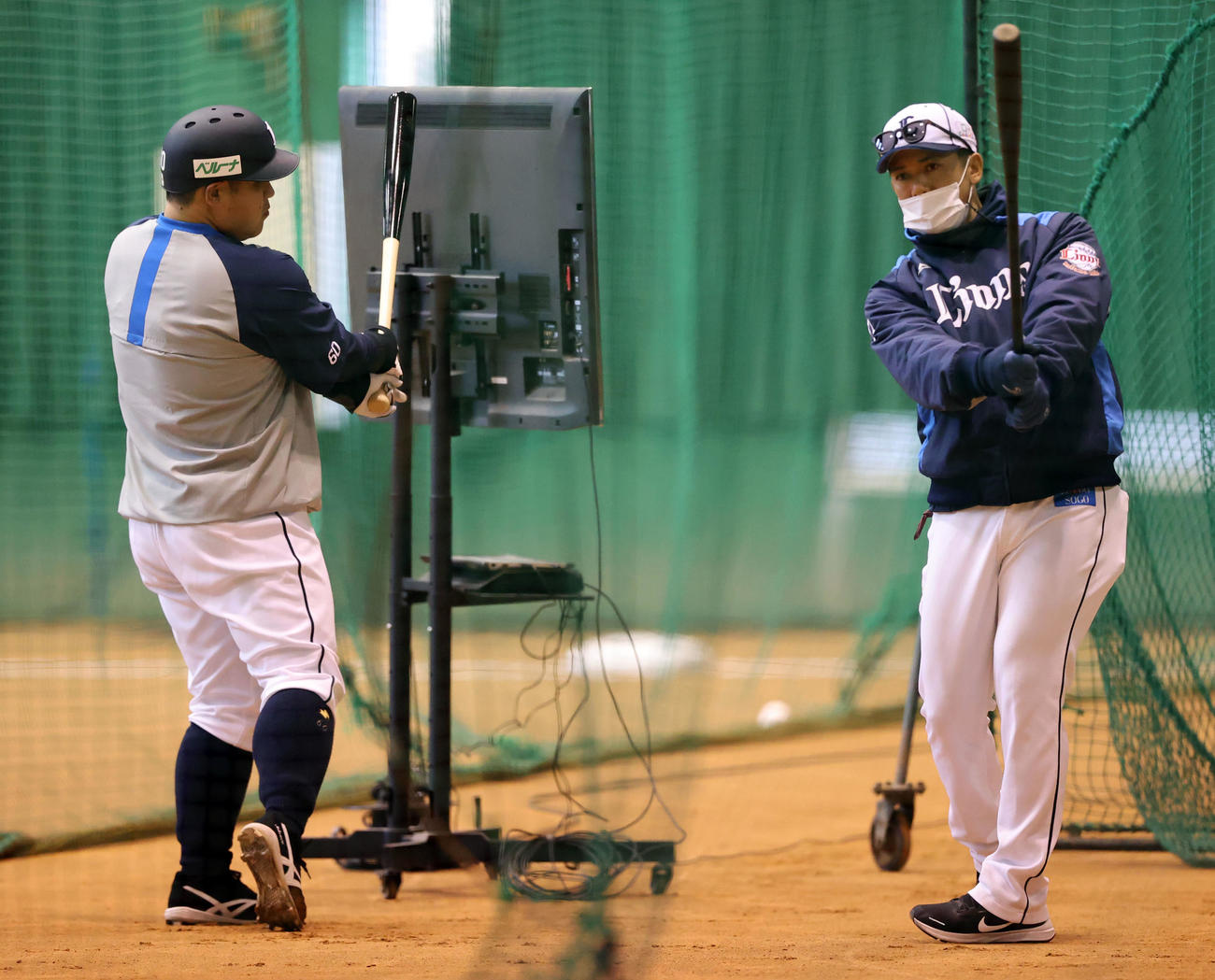 西武の春季キャンプ2日目、室内の打撃練習中、松井ヘッドコーチ（右）からアドバイスを受ける中村（撮影・浅見桂子）