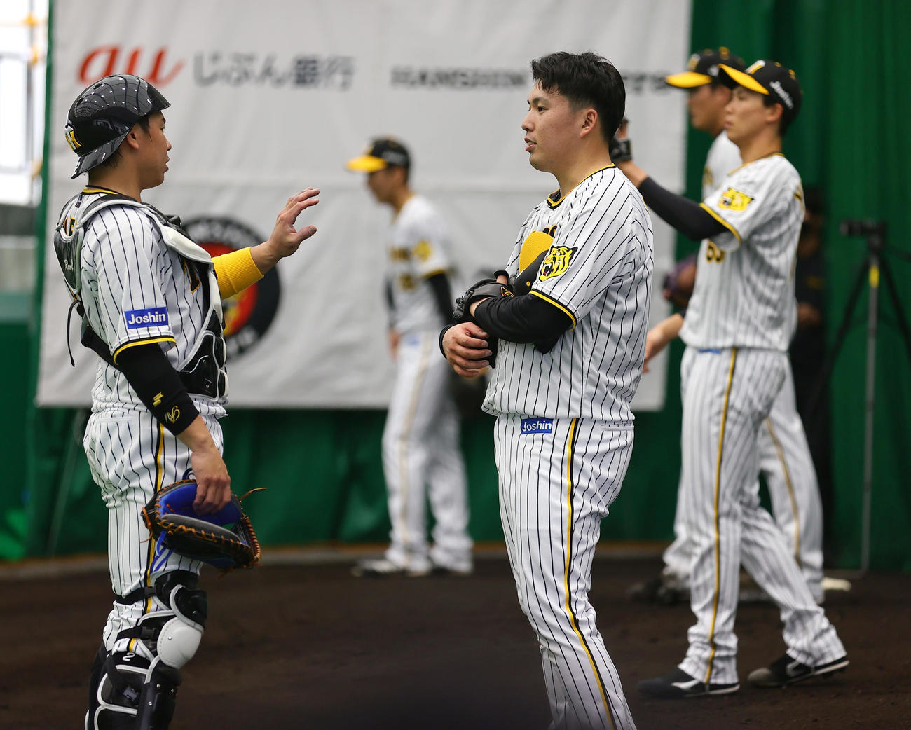 ブルペン投球を終えた阪神馬場皐輔（手前右）は梅野隆太郎の話を聞く（22年2月1日撮影）