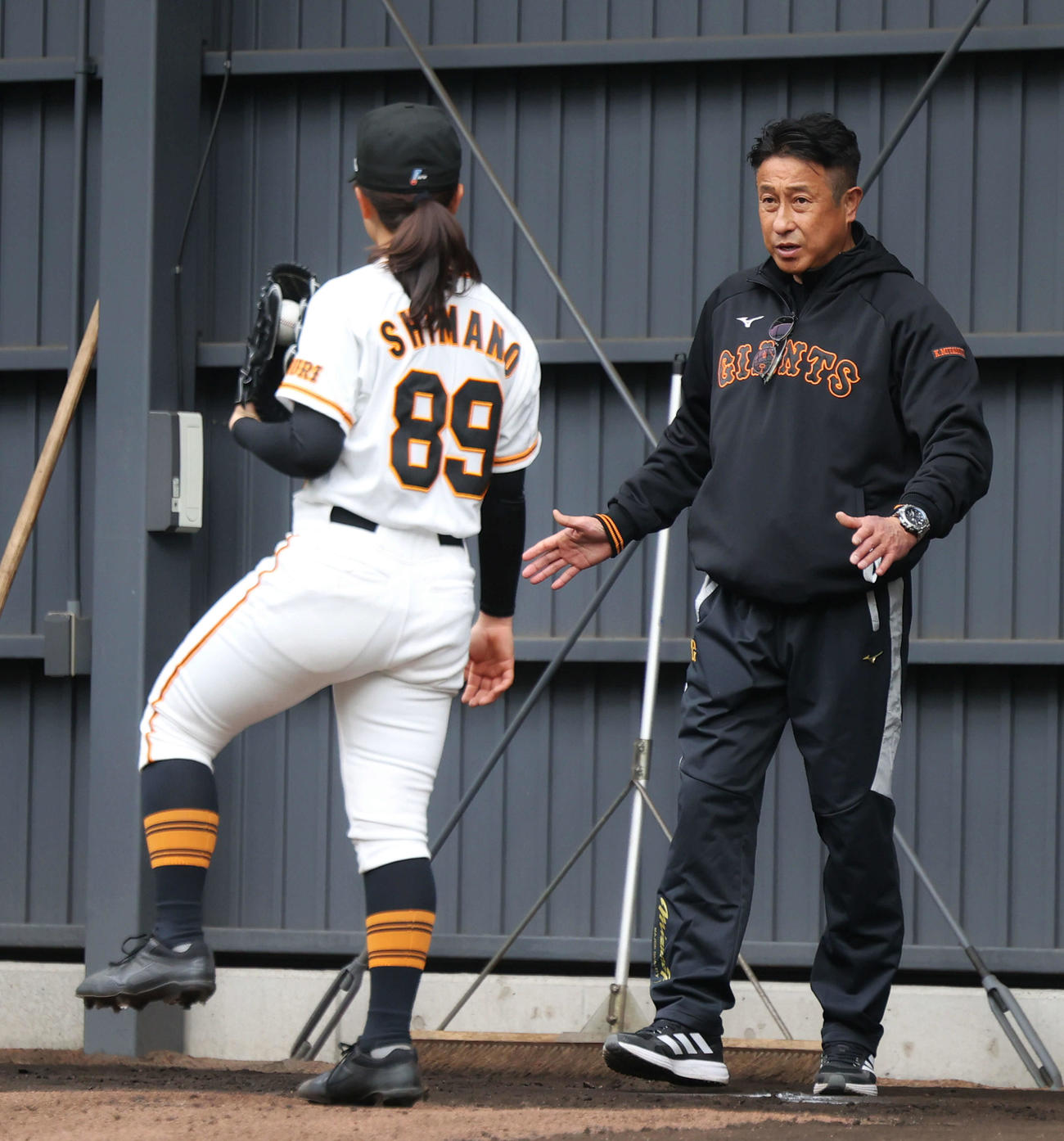 ブルペン投球する島野（左）にアドバイスする宮本アドバイザー（撮影・河田真司）