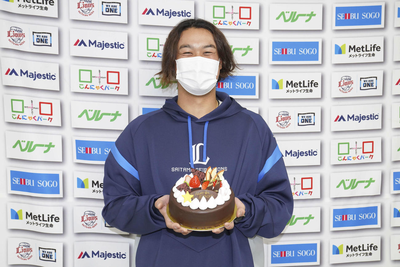 25歳の誕生日を迎え、笑顔でプレゼントされたケーキを手にする西武高橋（球団提供）