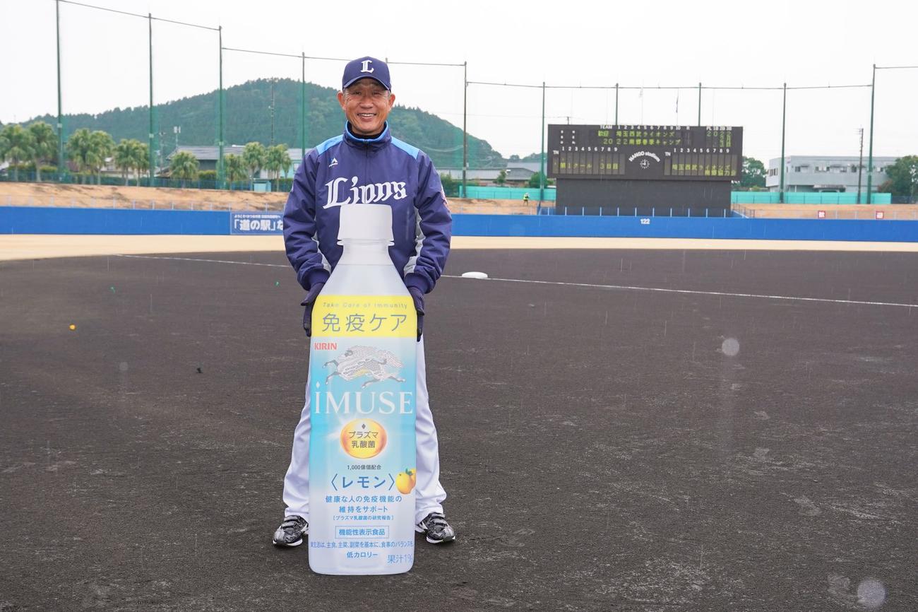 プレゼントされた飲料のパネルを持ち、笑顔の西武辻監督（球団提供）
