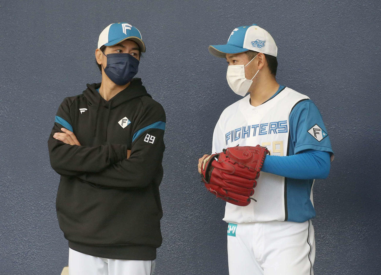 ブルペンで武田投手コーチ（左）と話す根本（撮影・黒川智章）