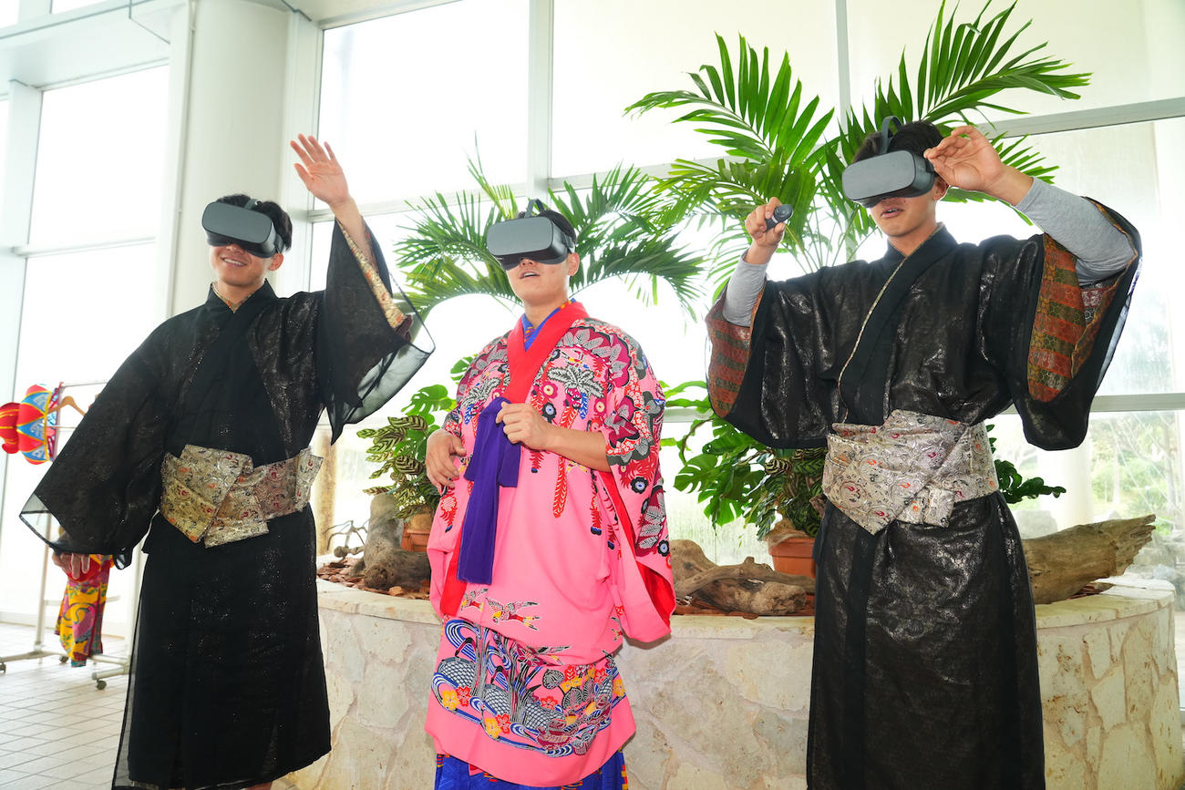 キャンプ初の休日で琉球衣装をまといダイビングスポットで有名なサンゴ礁が広がる宜野湾の海をVRゴーグルで体験するDeNA新人選手の、左から徳山、三浦、梶原（球団提供）