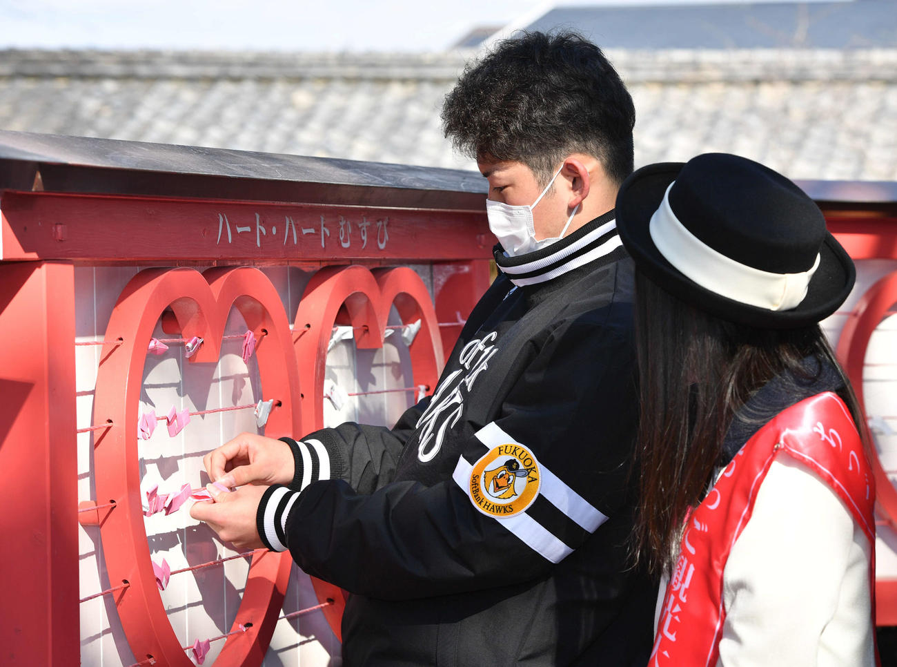 引いたおみくじを結ぶ風間（撮影・岩下翔太）