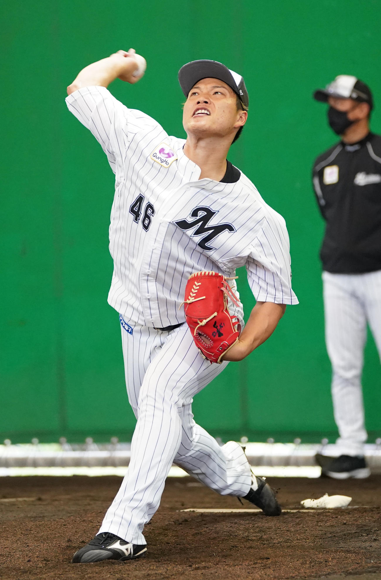 ブルペンで投球練習する岩下