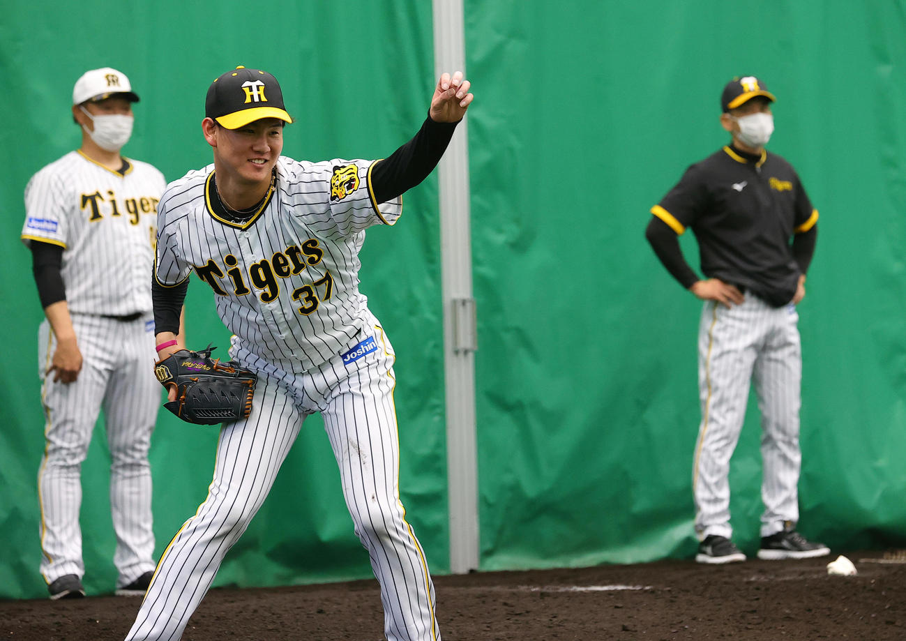 ブルペンで投球する及川雅貴。右は矢野監督、左は福原投手コーチ（2022年2月1日撮影）