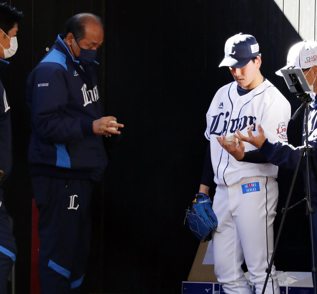 西武春季キャンプ4日目、ブルペン投球を終えた隅田（右）は渡辺GMと握りを確認する（撮影・浅見桂子）