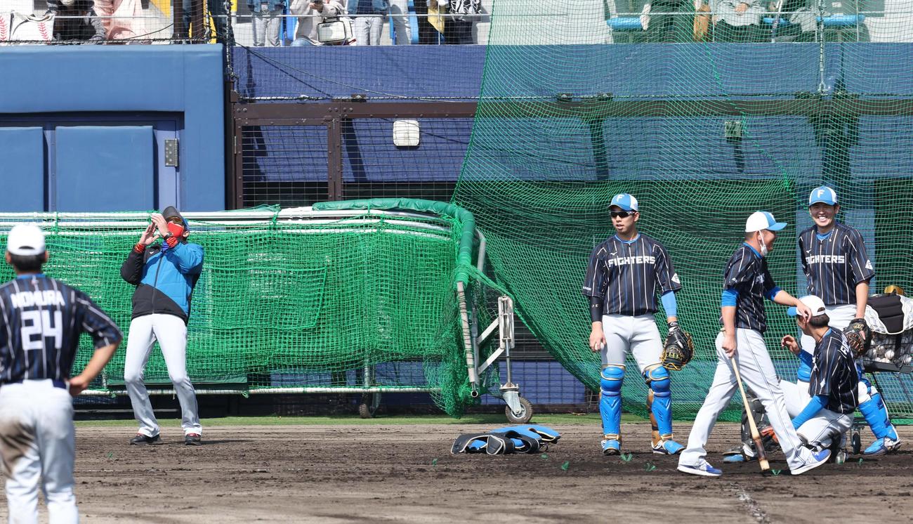 稲田内野守備走塁コーチ（右）がノックを失敗し思わずのけぞる日本ハム新庄監督（撮影・黒川智章）