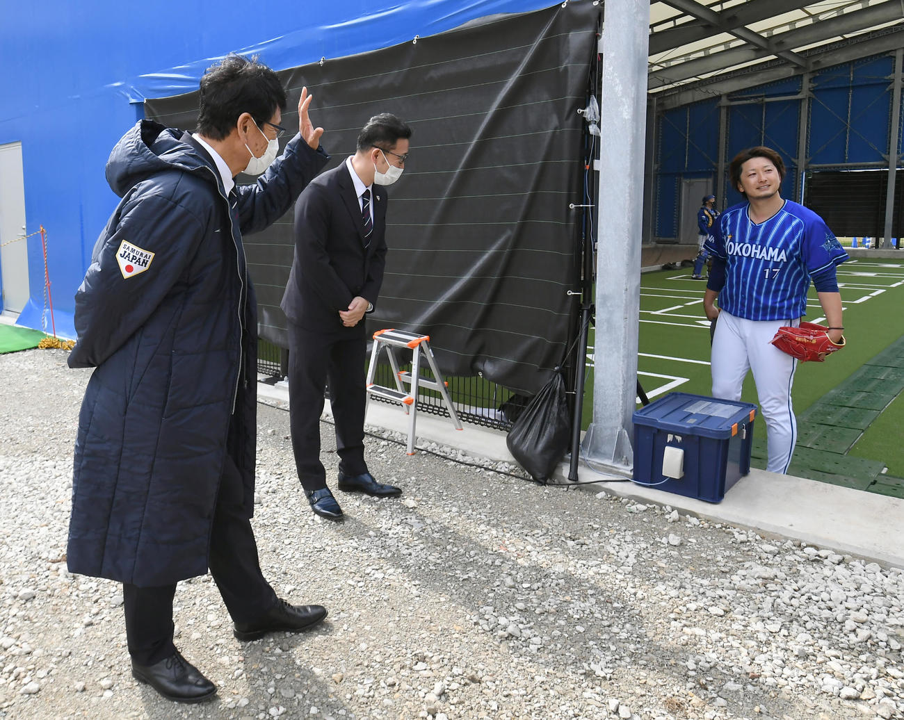 ブルペン調整を終えたDeNA三嶋（右）は宜野湾キャンプを訪問した日本代表の栗山監督にあいさつする（代表撮影）