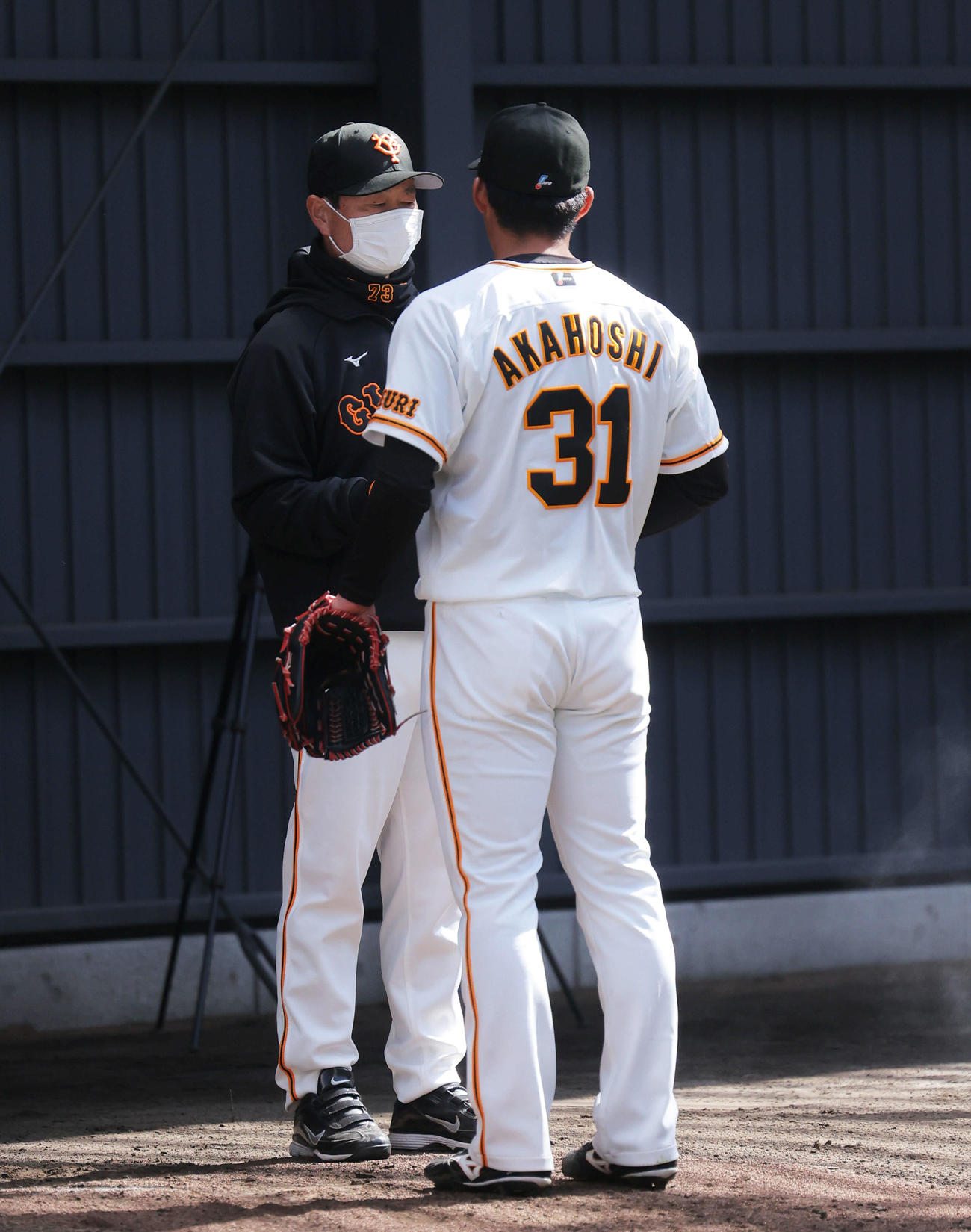 ブルペンで巨人桑田投手チーフコーチ（左）と言葉を交わす赤星（撮影・河田真司）