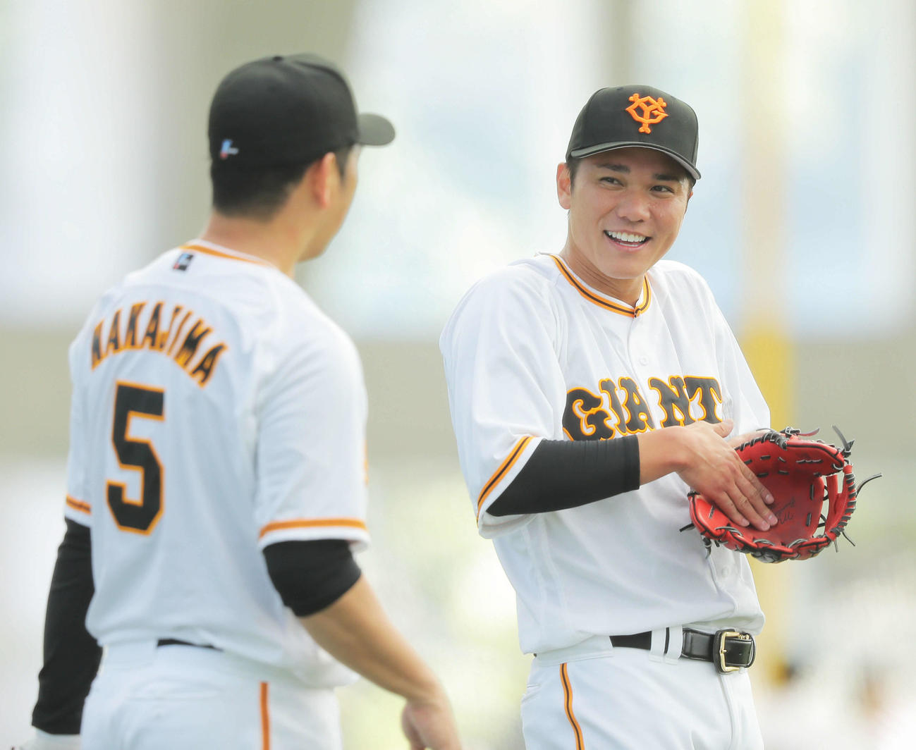 ノックを受け、笑顔で言葉を交わす巨人中島（左）と坂本（撮影・河田真司）