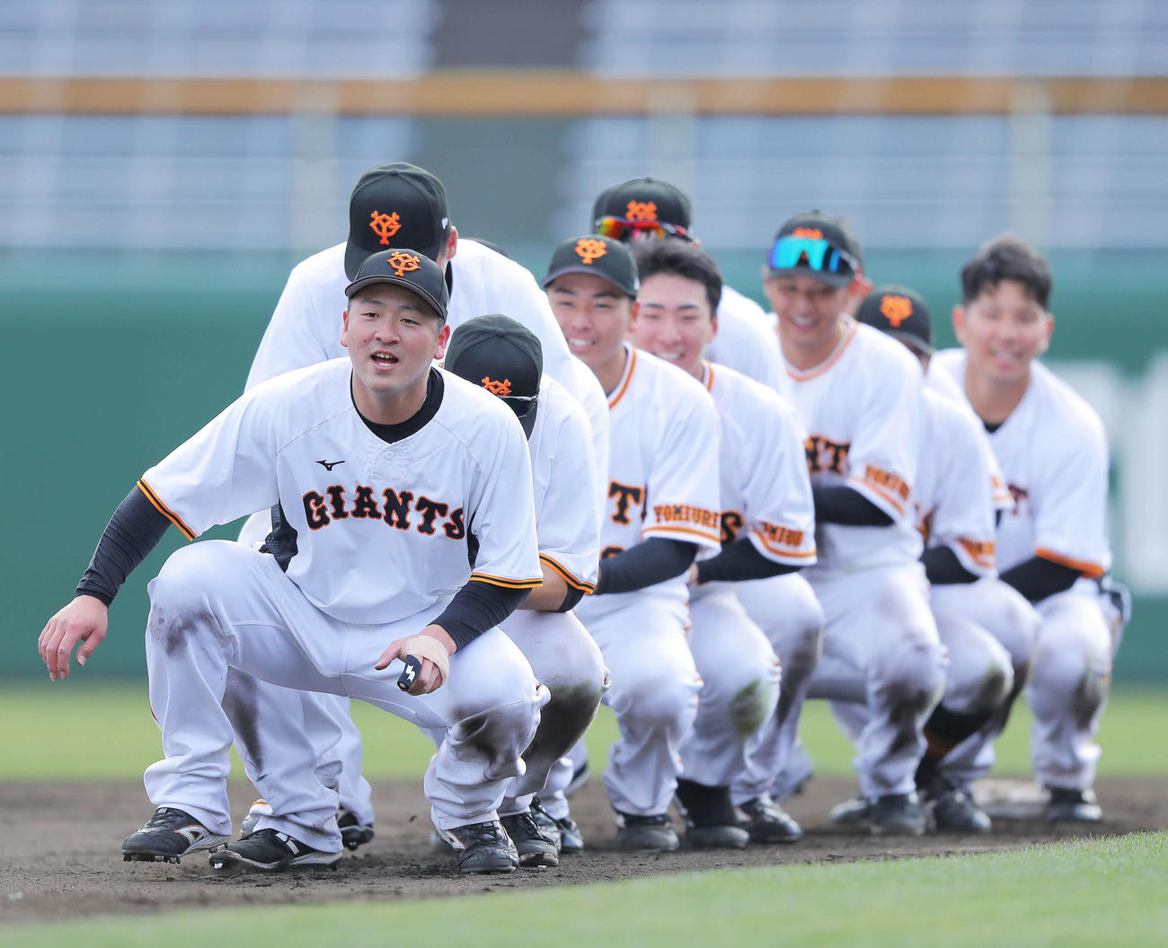 数珠つなぎでしゃがみながらベースを回るする巨人岸田（手前）ら野手陣（撮影・河田真司）