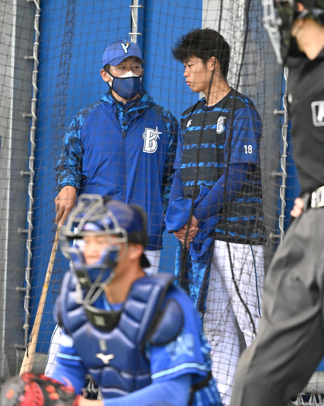 ブルペンで投手陣の投球を見守ったDeNA小園は三浦監督（中央）に声を掛けられる