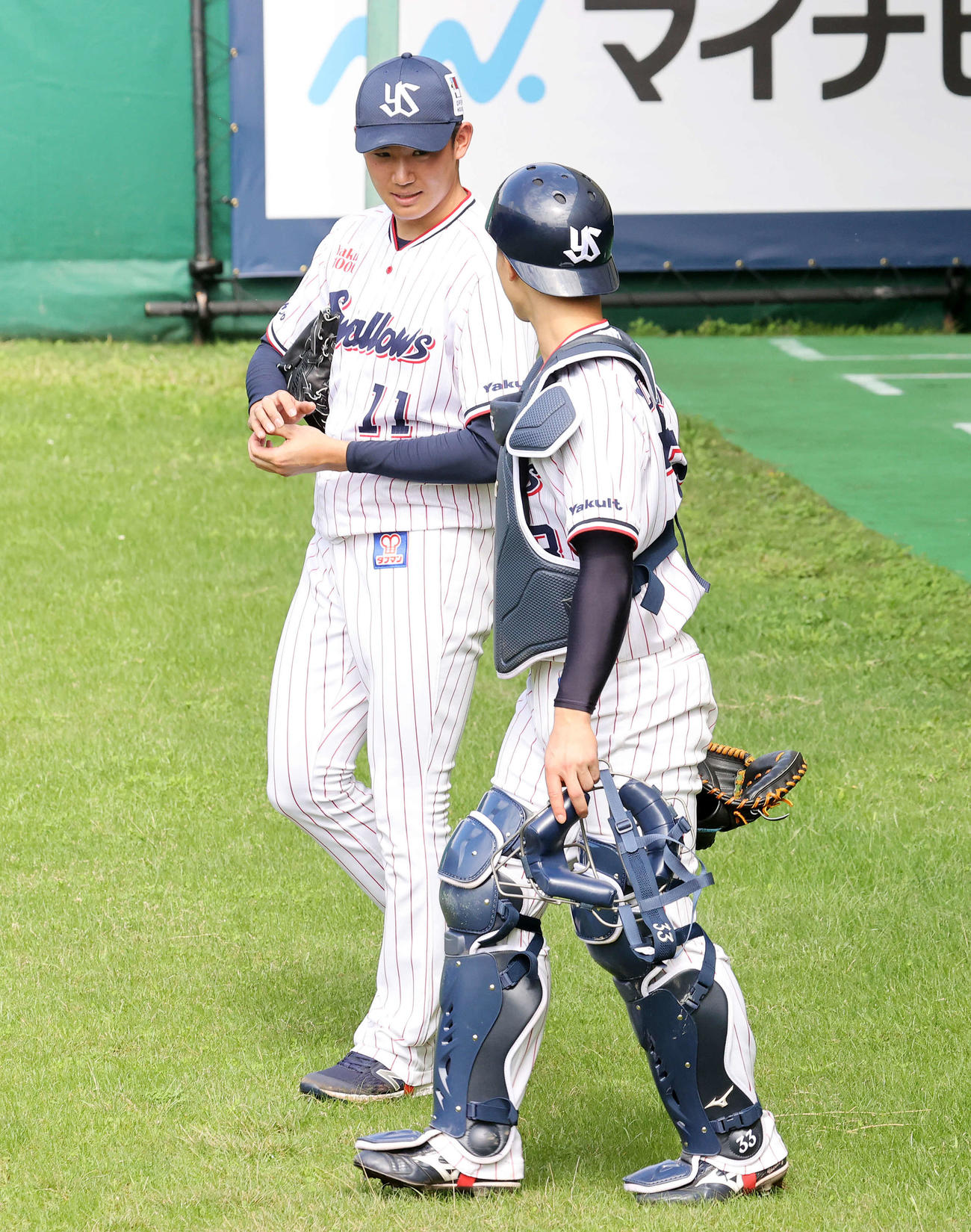投球練習後、内山壮（右）と話しながら引き揚げるヤクルト奥川（撮影・鈴木正人）