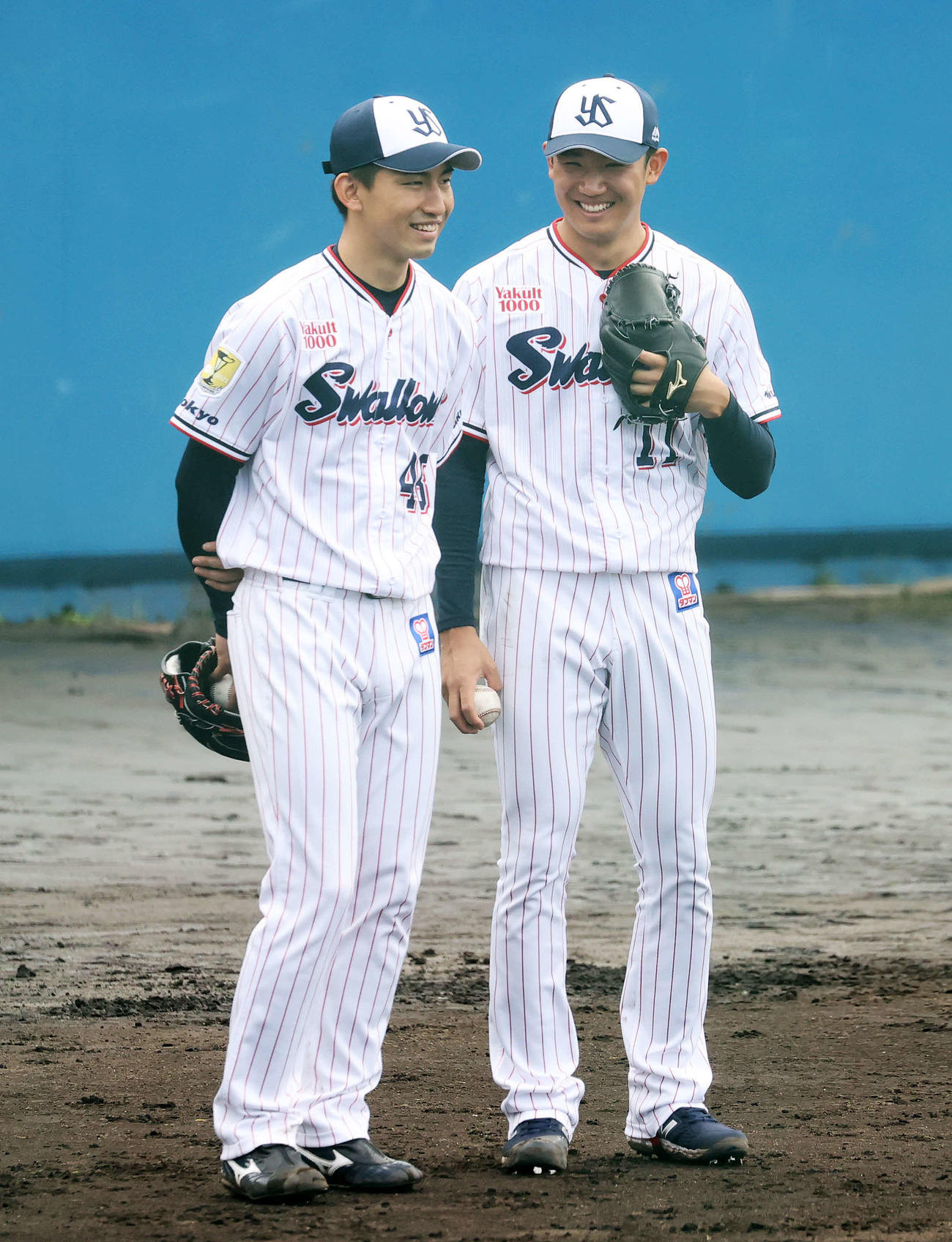 投内連係中、金久保（左）と笑顔で話すヤクルト奥川（撮影・鈴木正人）