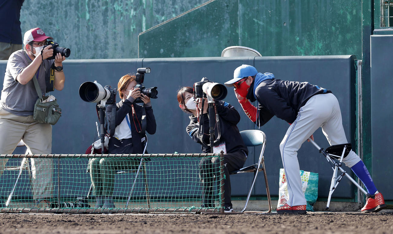 阪神対日本ハム　カメラマンが向けたレンズをのぞき込む日本ハム新庄監督（右）（撮影・前田充）
