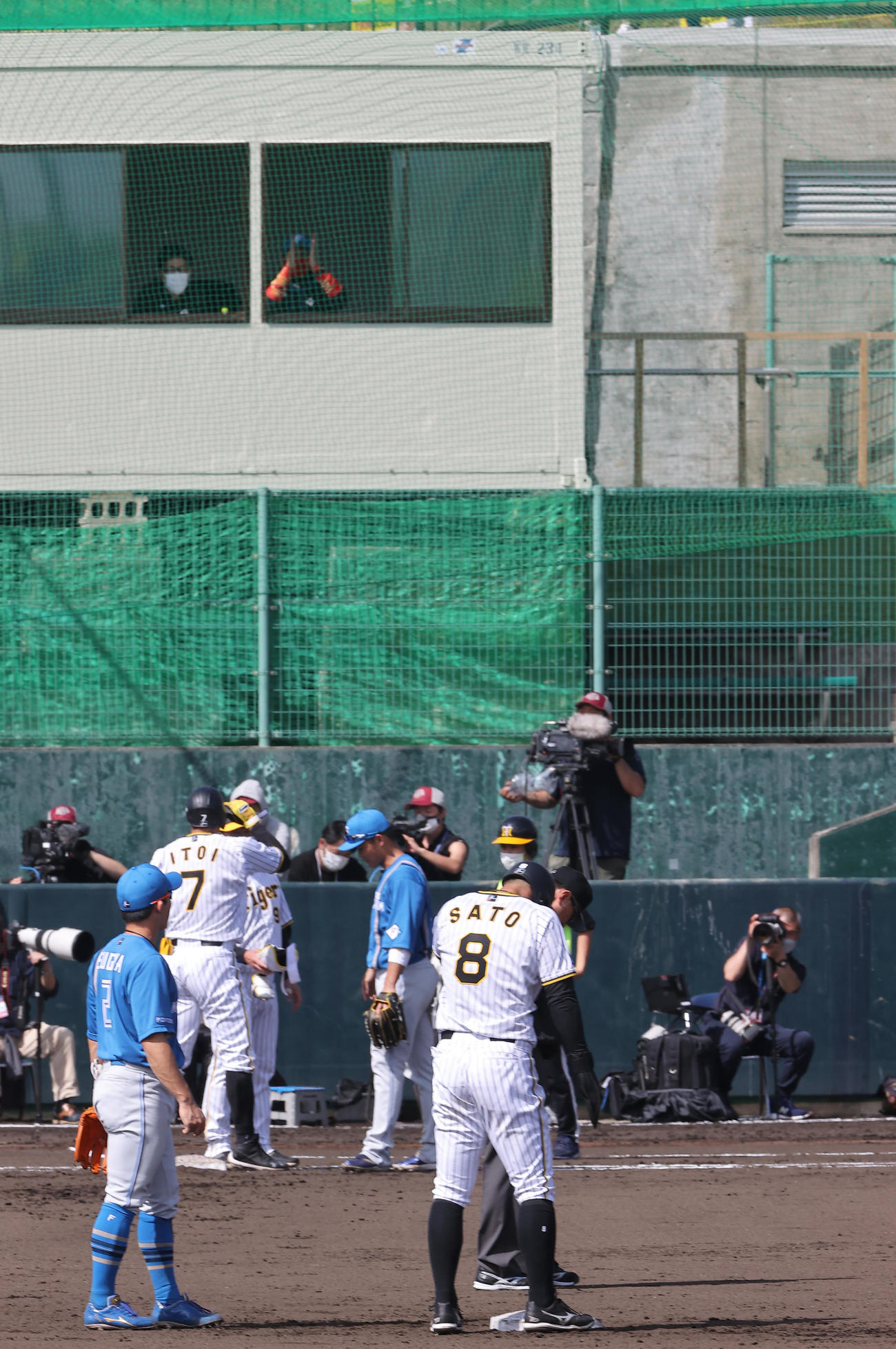 練習試合・阪神対日本ハム　1回裏阪神2死一塁、糸井（左から2人目）は左前打を放ち拍手する日本ハム新庄監督（右上）にあいさつする（撮影・上山淳一）